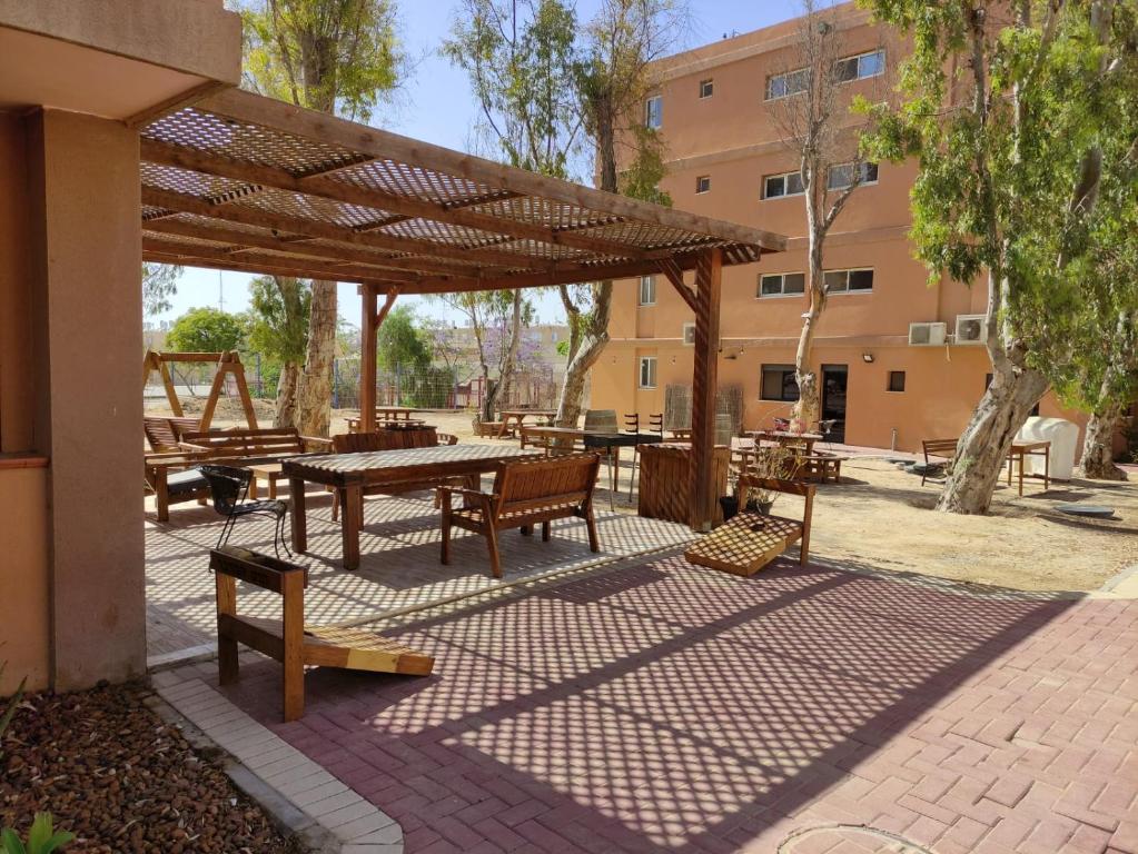 einen Picknickbereich mit einem Picknicktisch und Bänken in der Unterkunft Hadass Desert Inn in Dimona
