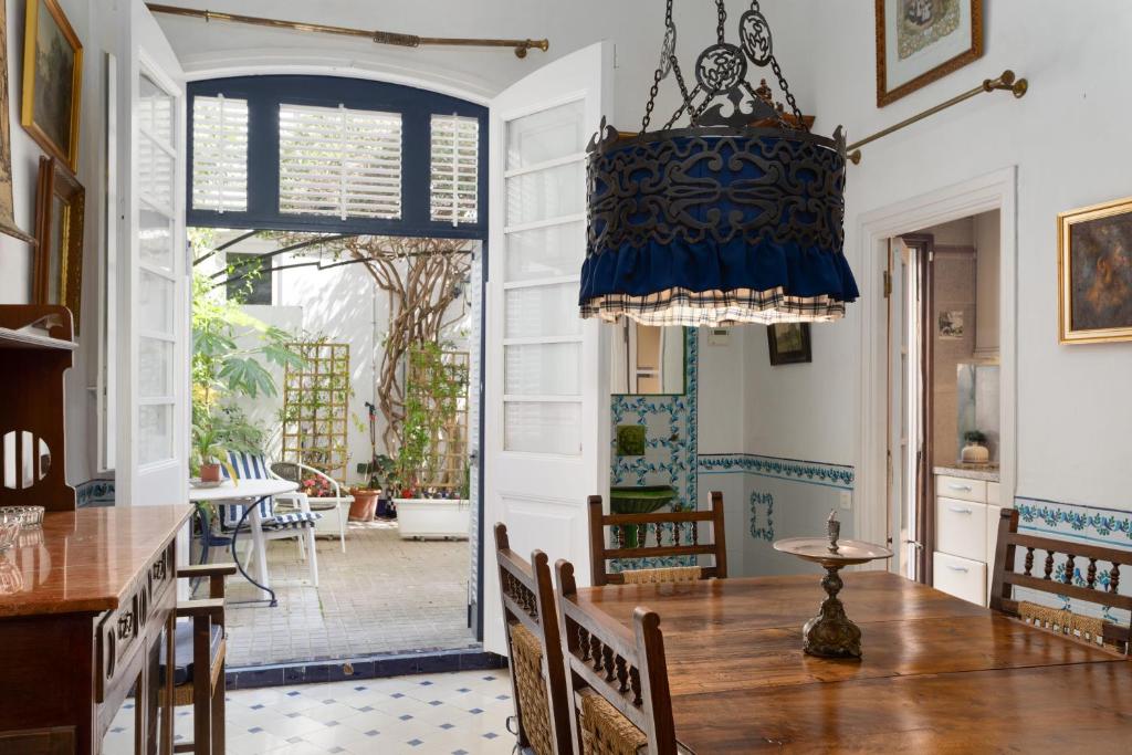 comedor con mesa y lámpara de araña en Hauzify I Casa Colonial, en Sant Pol de Mar