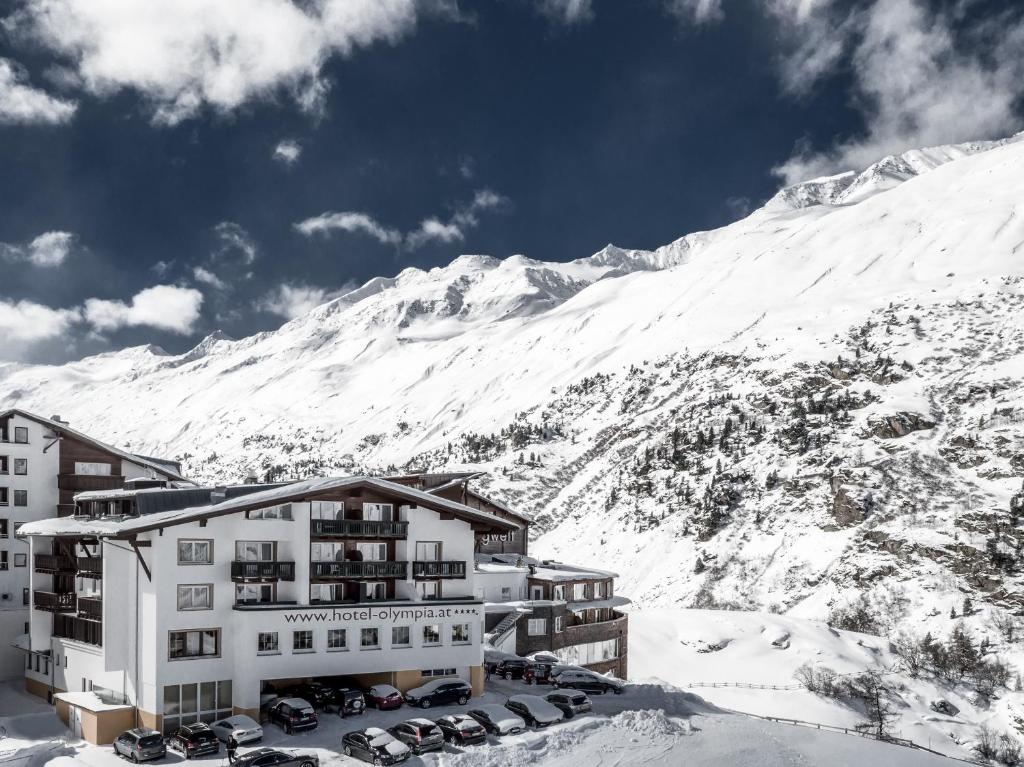 a hotel in the snow with a mountain in the background at Hotel Olympia in Obergurgl