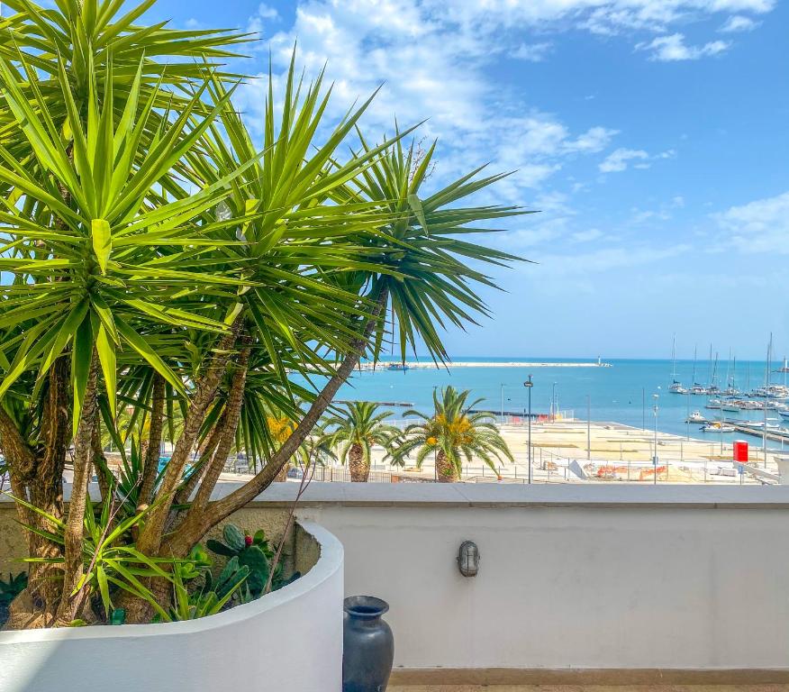 a view of the ocean from a balcony with palm trees at Terrazza Diomede- Manfredi Homes & Villas in Manfredonia