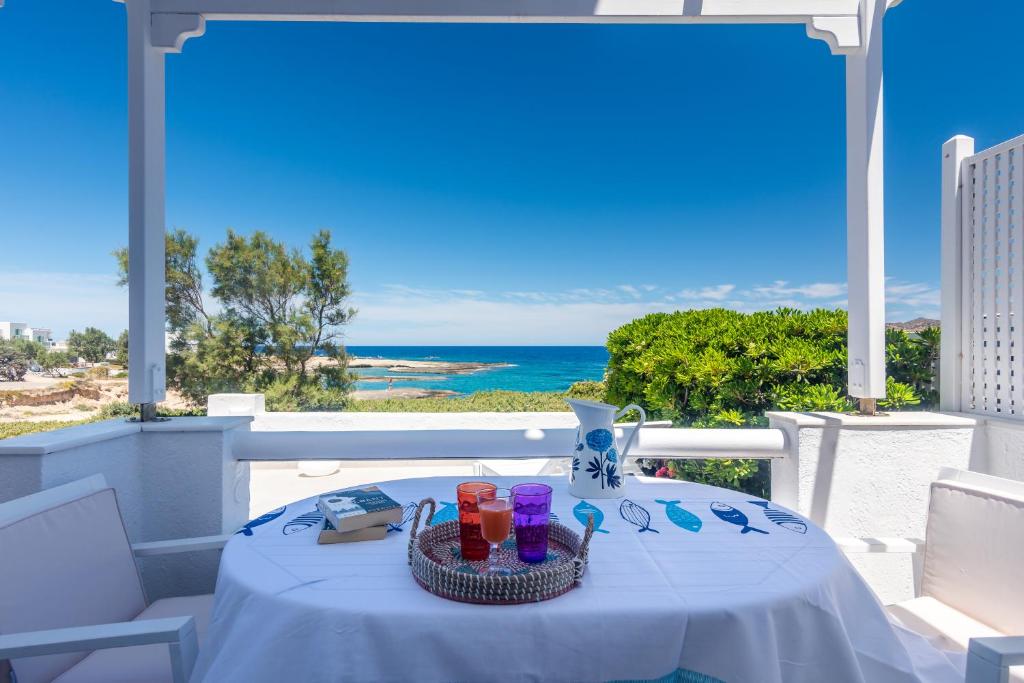a table on a balcony with a view of the ocean at ARTEMIS by Akroploro in Pollonia