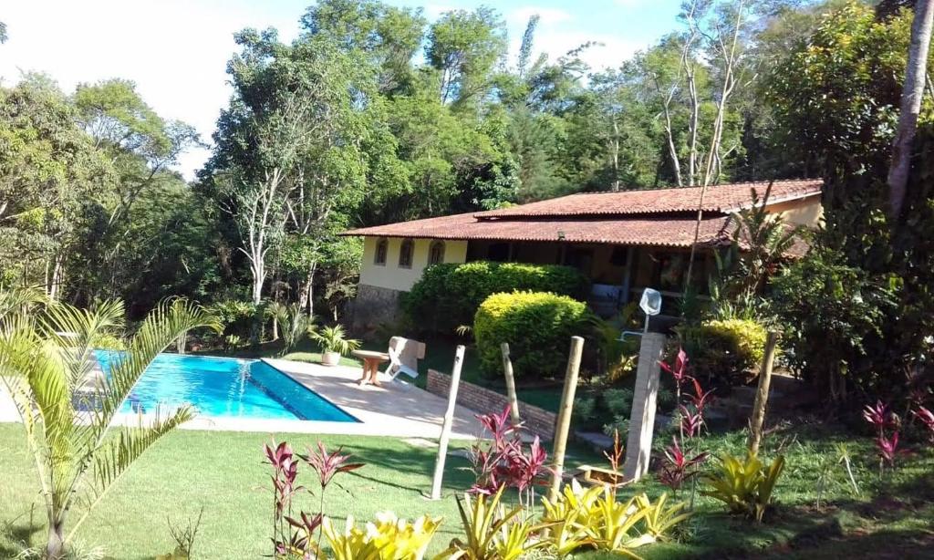 帕蒂杜阿爾費里斯的住宿－Belíssima Casa Sitio em Condomínio na Serra - Paty do Alferes，庭院中带游泳池的房子