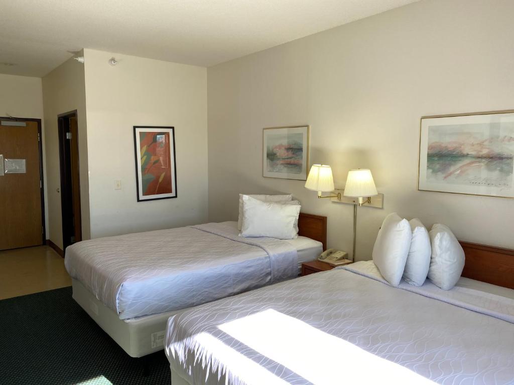 Carlyle的住宿－Carlyle Inn & Suites，酒店客房设有两张床和两盏灯。
