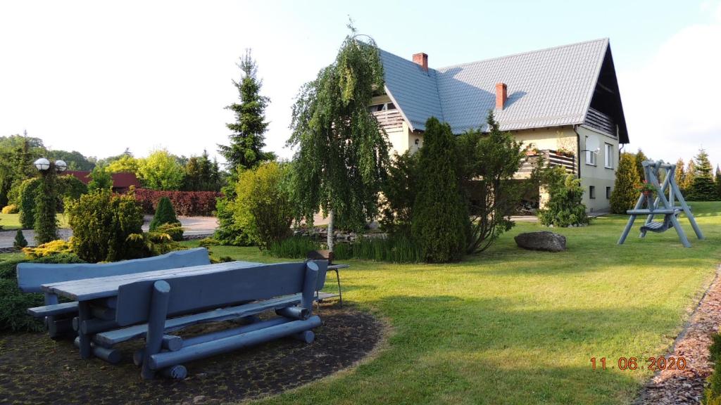 dom z niebieską ławką w ogrodzie w obiekcie Zielone Tarasy na Kaszubach w mieście Sikorzyno