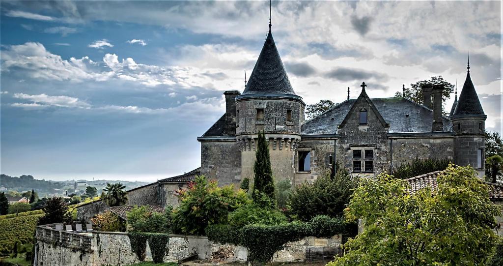 Stary zamek z dwoma wieżami na górze w obiekcie Chateau de la Grave w mieście Bourg-sur-Gironde