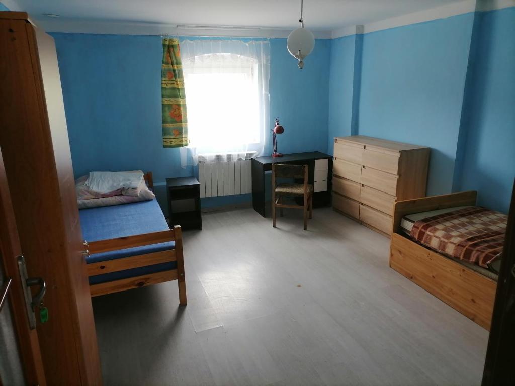 a bedroom with two beds and a desk and a window at U Bronka w Książęcym Lesie in Niedaszów