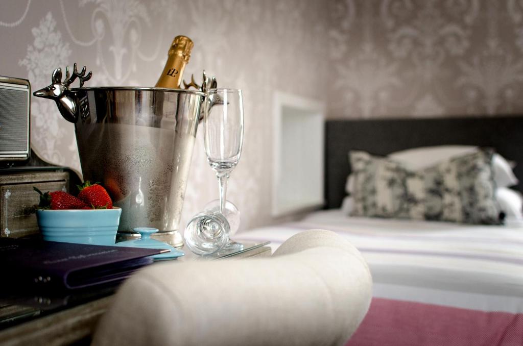 a bedroom with a bed and a table with a bottle of champagne at Kingsway Guest House in Edinburgh