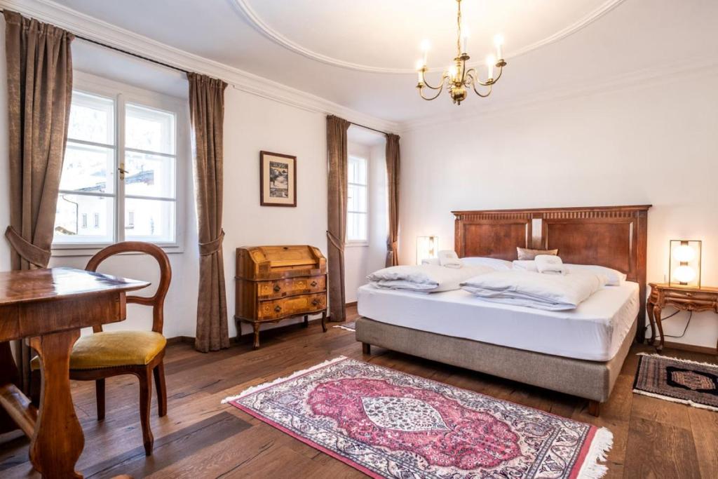 1 dormitorio con cama, mesa y piano en Stammhaus - Premium Residences, en Rauris