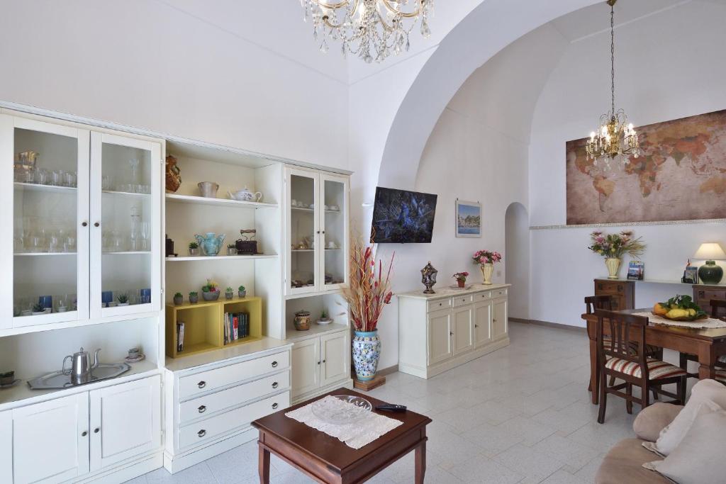 een woonkamer met witte kasten en een tafel bij Casa del Fauno in Minori