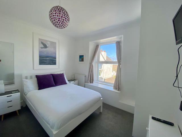 セント・アイヴスにあるCoast Accommodationの白いベッドルーム(ベッド1台、窓付)
