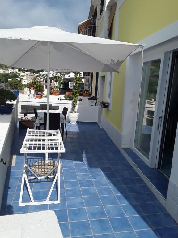 eine Terrasse mit einem Tisch und einem Sonnenschirm in der Unterkunft Da Lucia - Alloggio turistico Santa Maria in Ponza