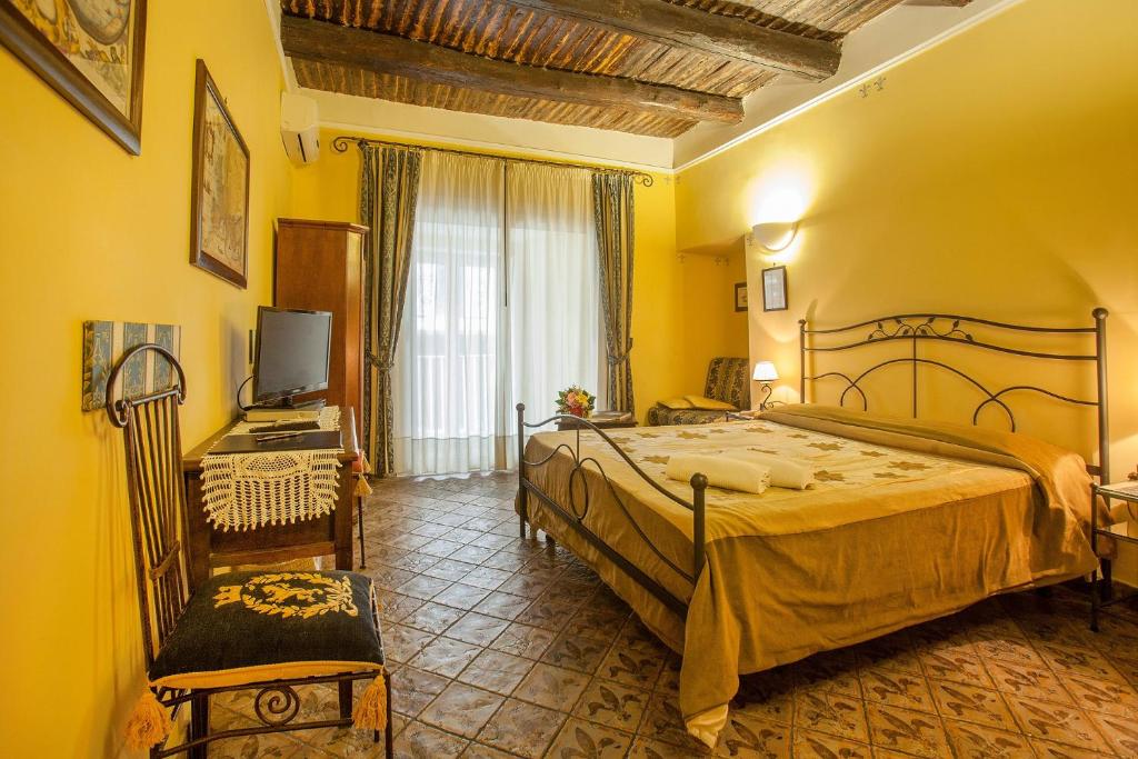 een slaapkamer met een bed, een bureau en een televisie bij B&B L'Alloggio Dei Vassalli in Napels