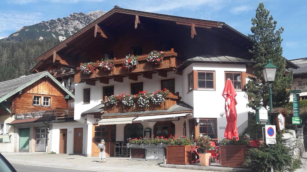 un edificio con cajas de flores en la parte delantera en Mesnerhaus Filzmoos, en Filzmoos