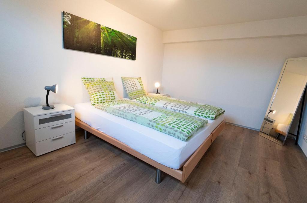 um quarto com uma cama com uma mesa de cabeceira e uma cama sidx sidx sidx em Hôtel Bellavista "Bellevue" em Saignelégier