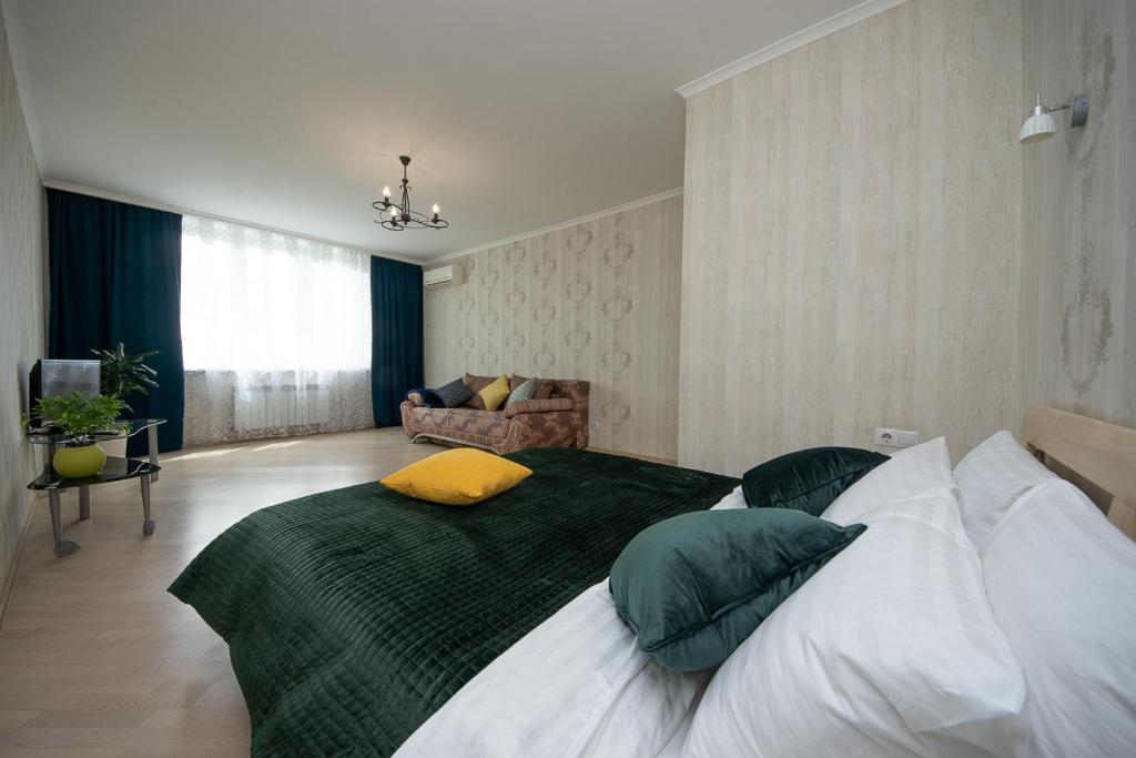 a bedroom with a large bed with green and white pillows at N.A.N Apartments on Osokorky in Kyiv