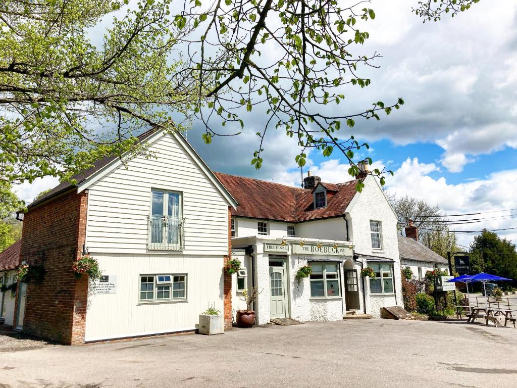 Casa blanca con un edificio de ladrillo en The Roebuck Inn en Laughton