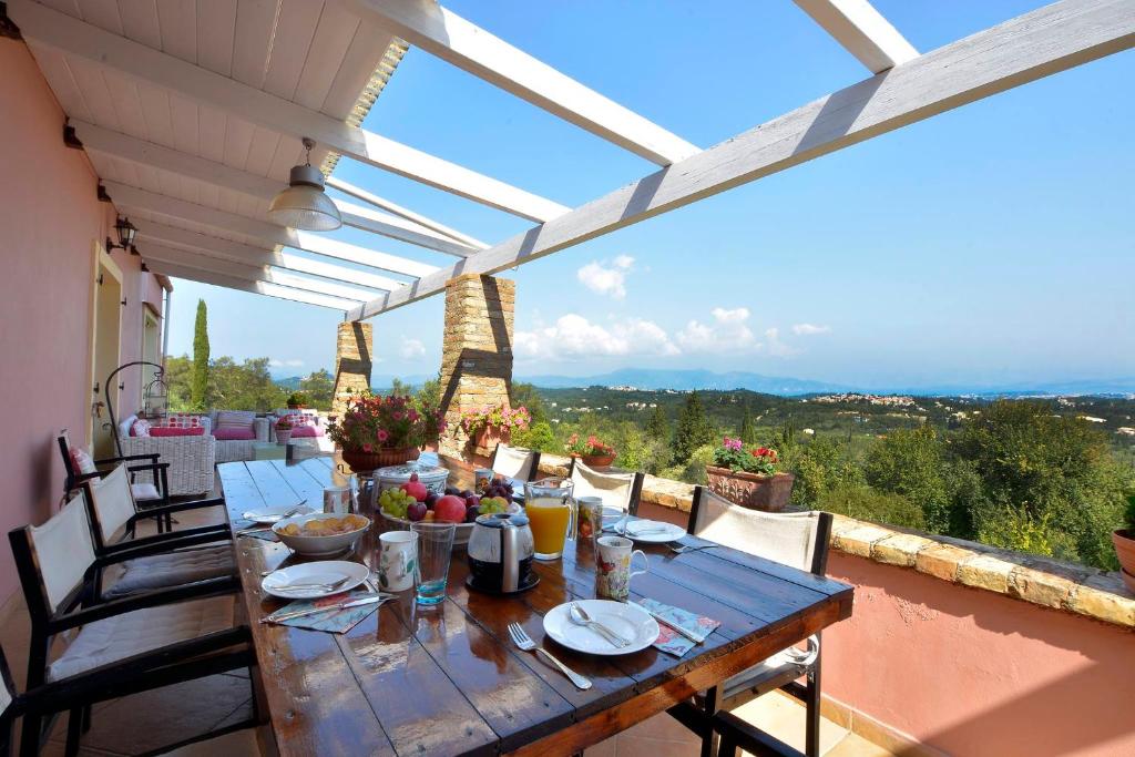 a wooden table on the balcony of a house at Villa Kardami -country house in Agios Gordios