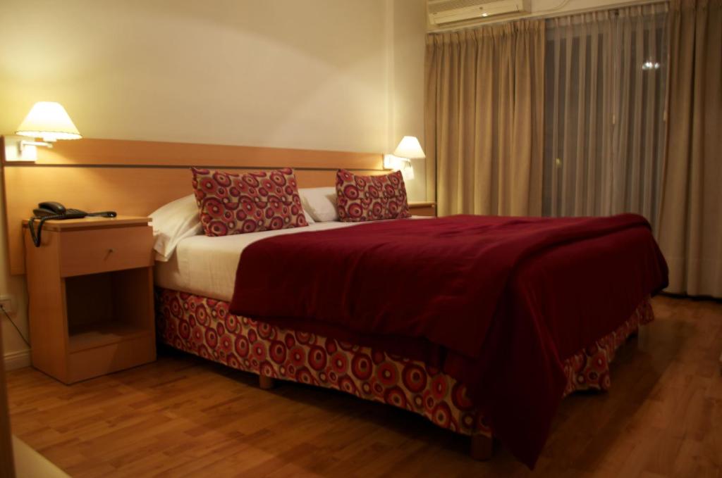 a hotel room with a bed with red pillows at Apart San Diego Recoleta in Buenos Aires