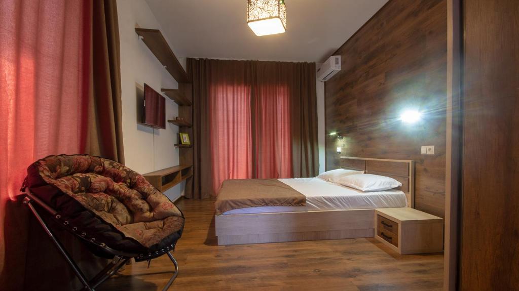 a bedroom with a bed and a chair in it at Check inn Delisi in Tbilisi City