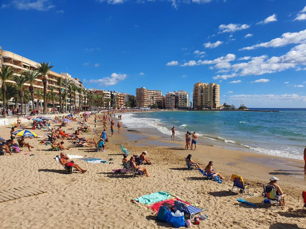 un groupe de personnes assises sur une plage dans l'établissement Casa Margarita, à Torrevieja