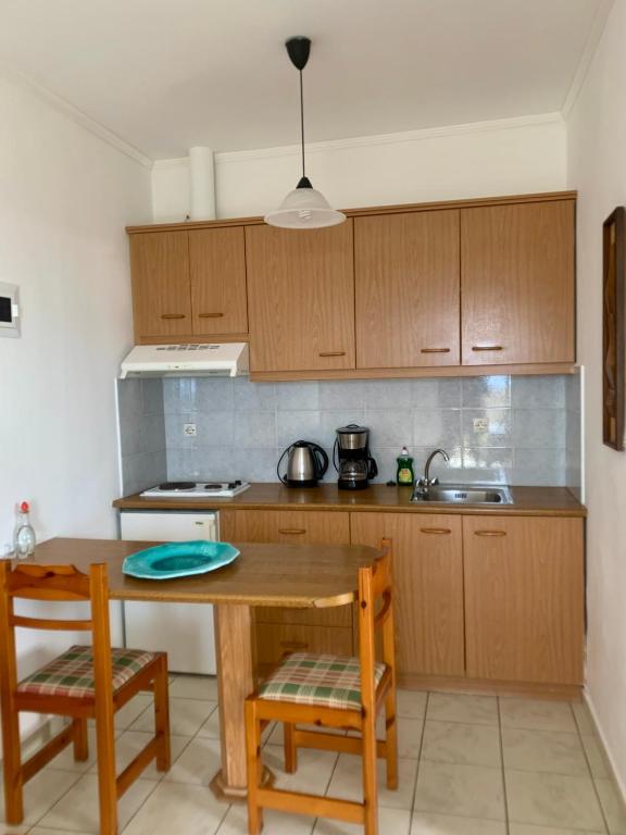 a kitchen with wooden cabinets and a wooden table and chairs at Irene Komos in Pitsidia