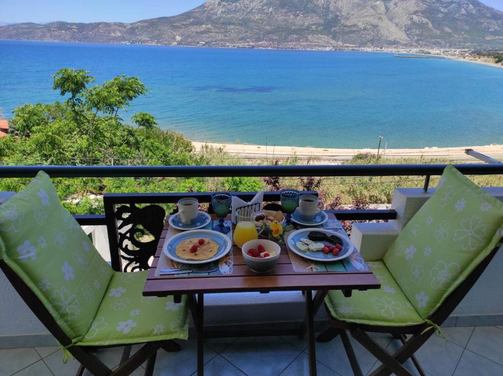 a table with food and a view of the ocean at Seaside Sunset in Korinthos