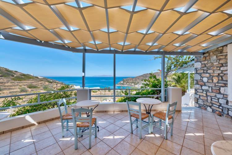 a patio with tables and chairs and a view of the ocean at APOLLON PALACE in Kini
