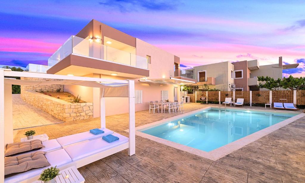 a villa with a swimming pool in front of a house at Allas Villa Heated Pool in Chania Town