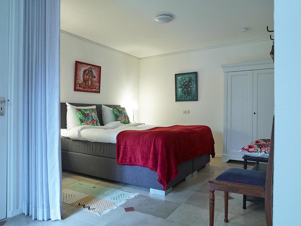 een slaapkamer met een bed met een rode deken bij Studio # Het Pauwennest in Den Bosch