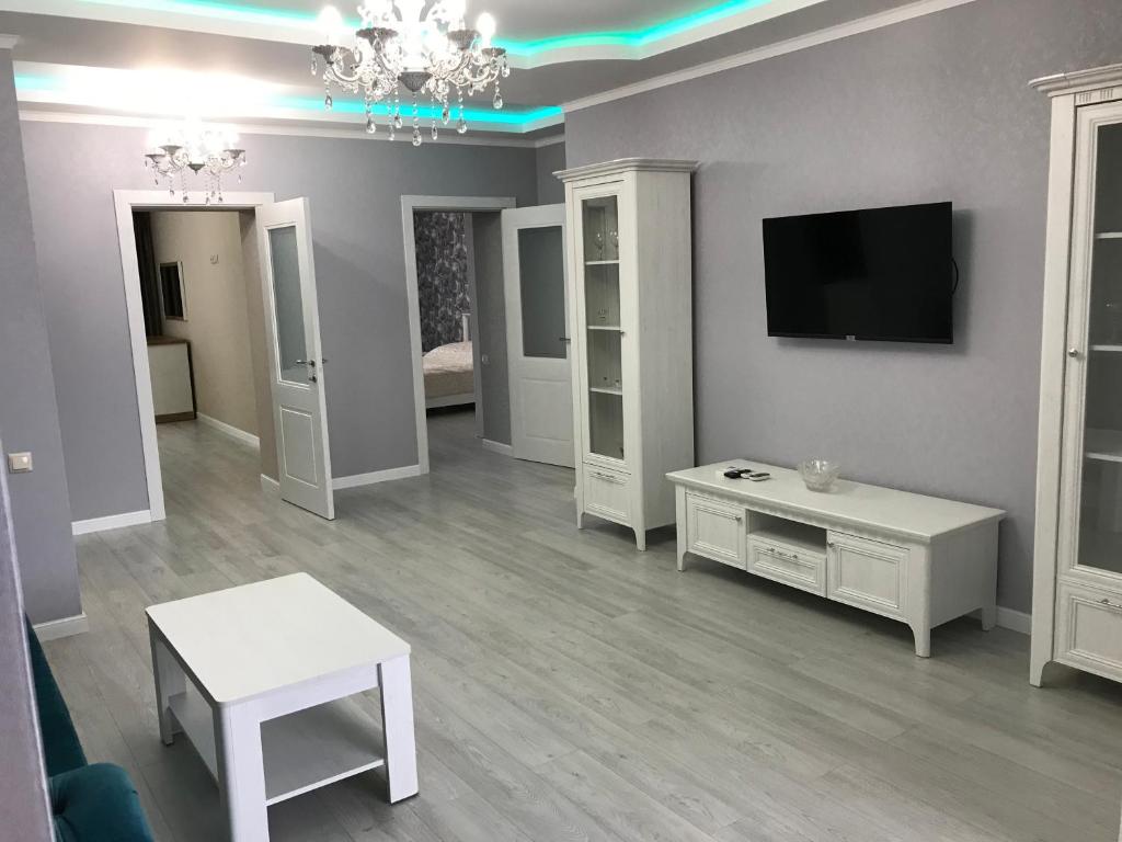 a white living room with a tv and a table at Квартира 3-комнатная ЛЮКС in Sukhum