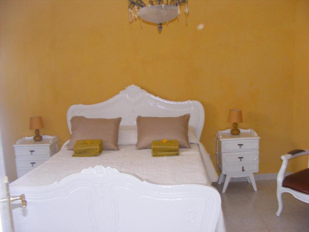 a bedroom with a white bed with two night stands at Casa Thocamalu's in Covelo