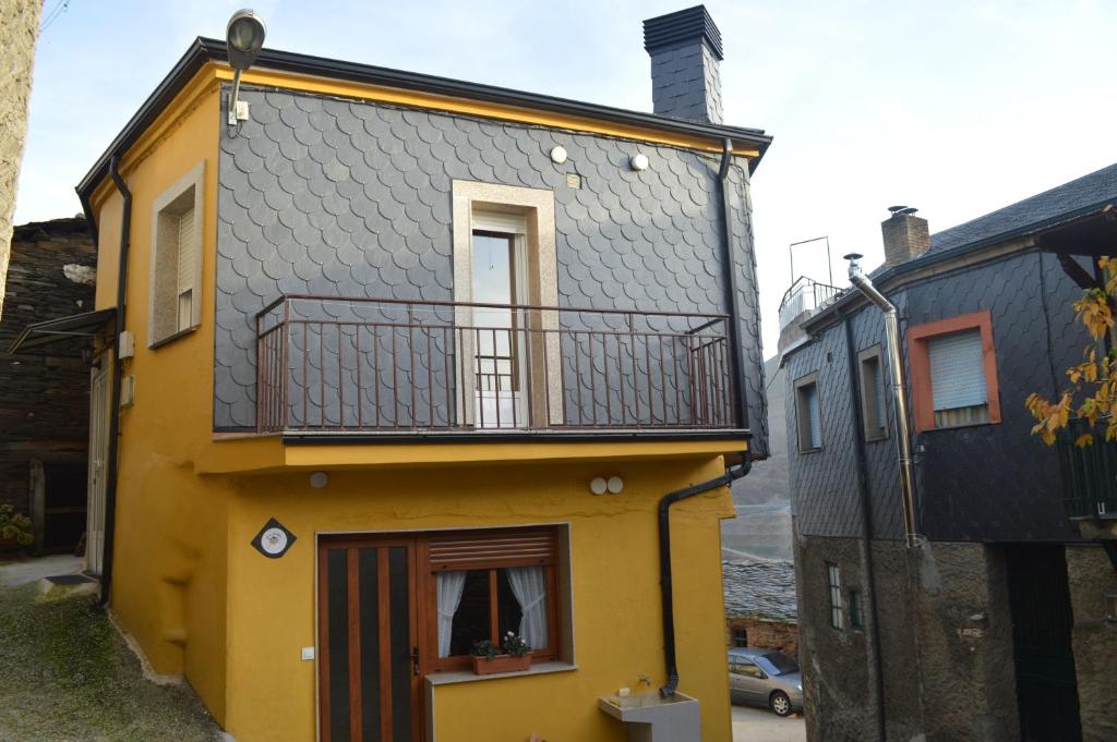 Casayo的住宿－Casa Gelita，黄色的建筑,上面设有阳台