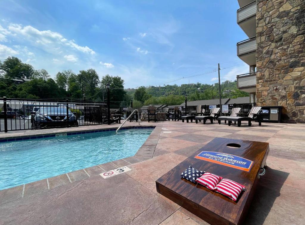 Uma piscina olímpica com uma mesa com bandeiras americanas. em Howard Johnson by Wyndham Downtown Gatlinburg em Gatlinburg