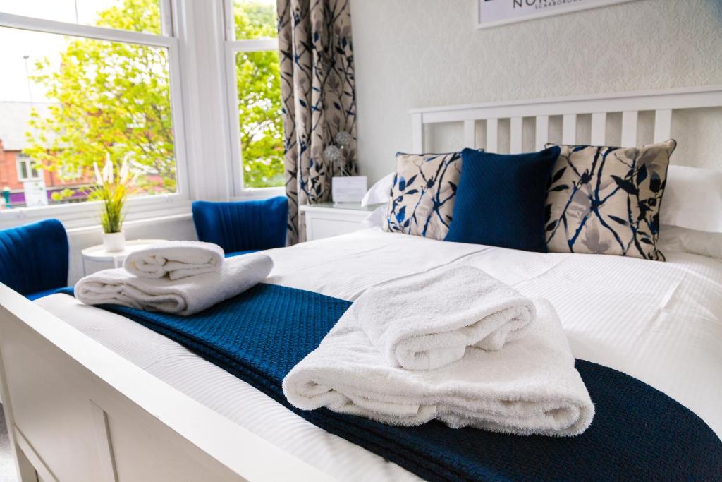 a bedroom with a bed with towels on it at Kingsway Guesthouse - A selection of Single, Double and Family Rooms in a Central Location in Scarborough