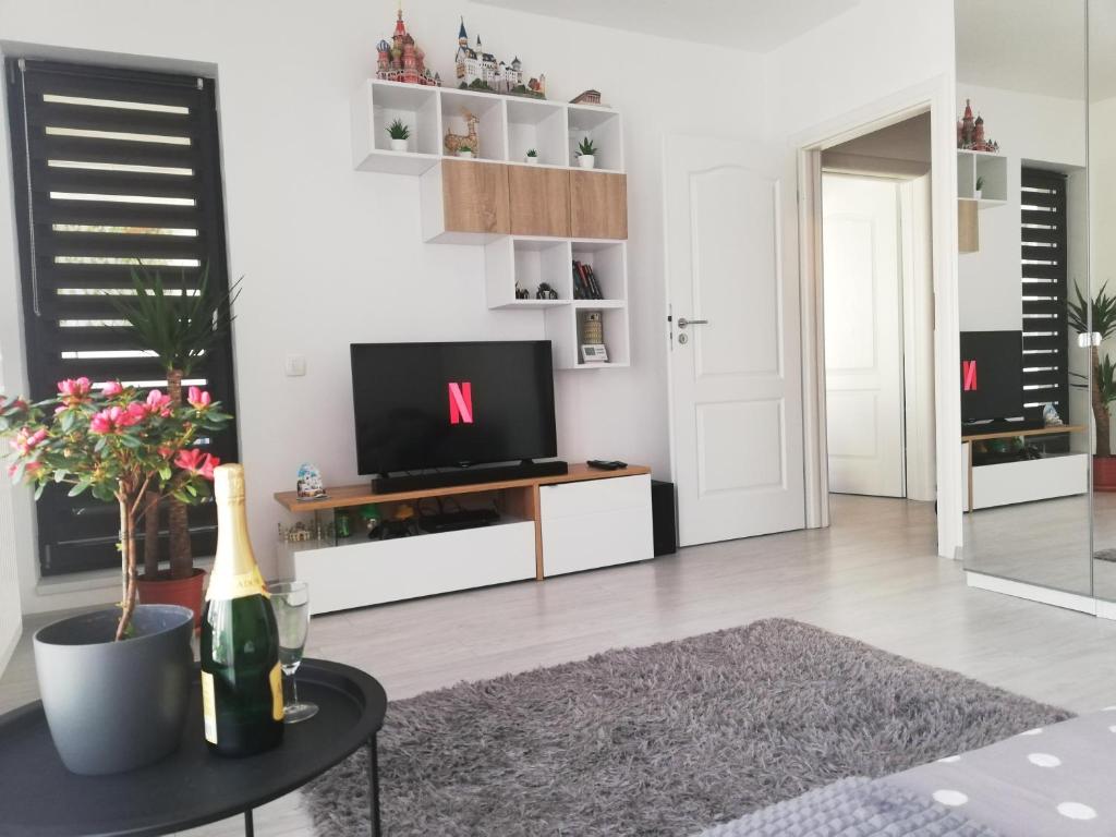 un soggiorno con TV e tavolo di Marlen’s Apartment a Bucarest