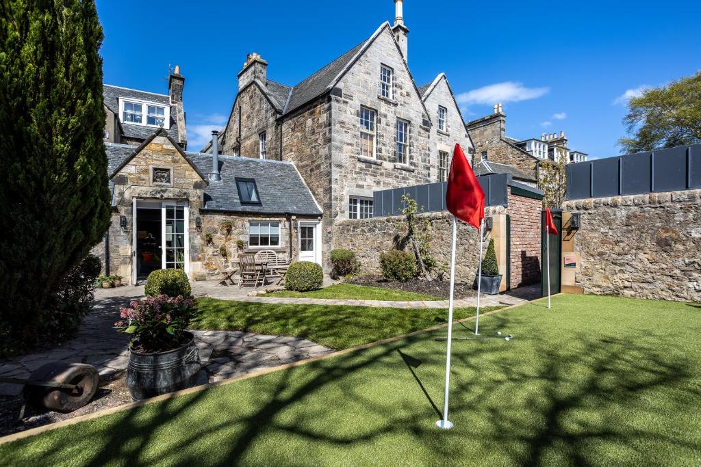 una casa con bandiera rossa nel cortile anteriore di No1 St Andrews and Westpark House Bedrooms a St Andrews