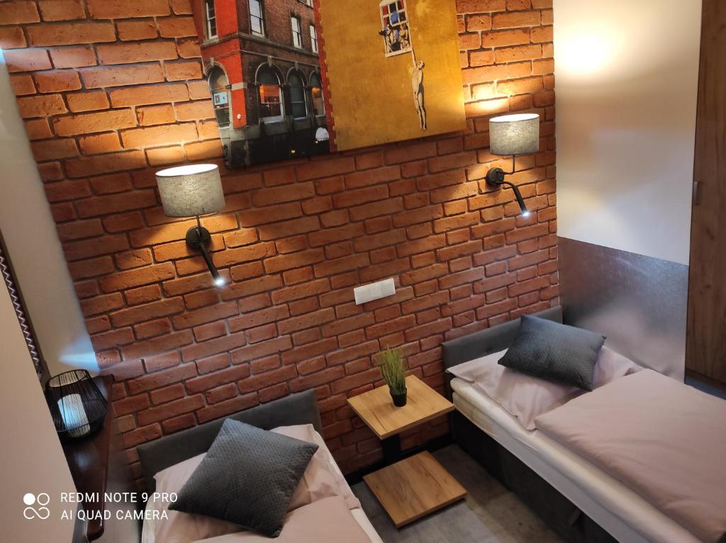 sala de estar con pared de ladrillo y sofá en Apartament Aurora Kletno en Stronie Śląskie