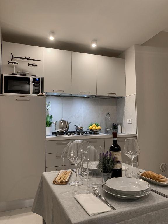 a kitchen with a table with plates and wine glasses at Villa Luminosa in Torre del Lago Puccini