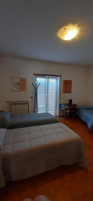 Un dormitorio con una cama grande y una ventana en Locanda dei miracoli, en Pizzoli