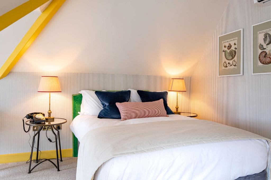 a bedroom with a large white bed with two lamps at The Canford in Poole
