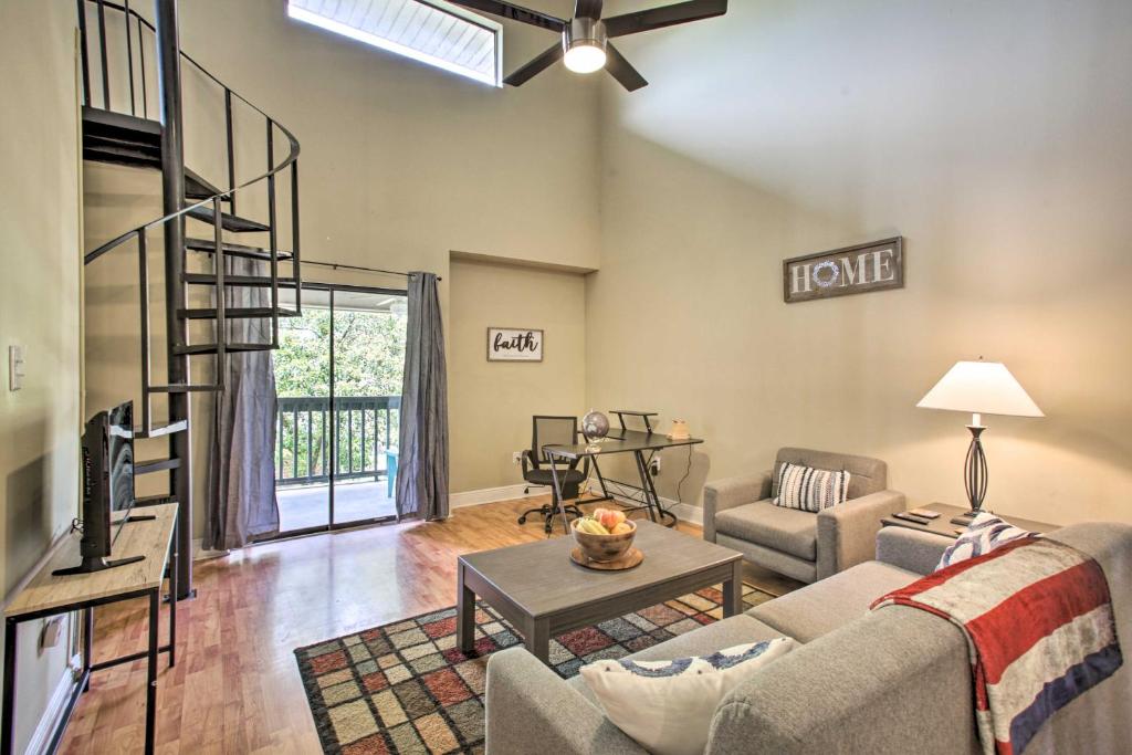 a living room with a couch and a spiral staircase at Baton Rouge Condo Less Than 3 Mi to Tiger Stadium! in Baton Rouge