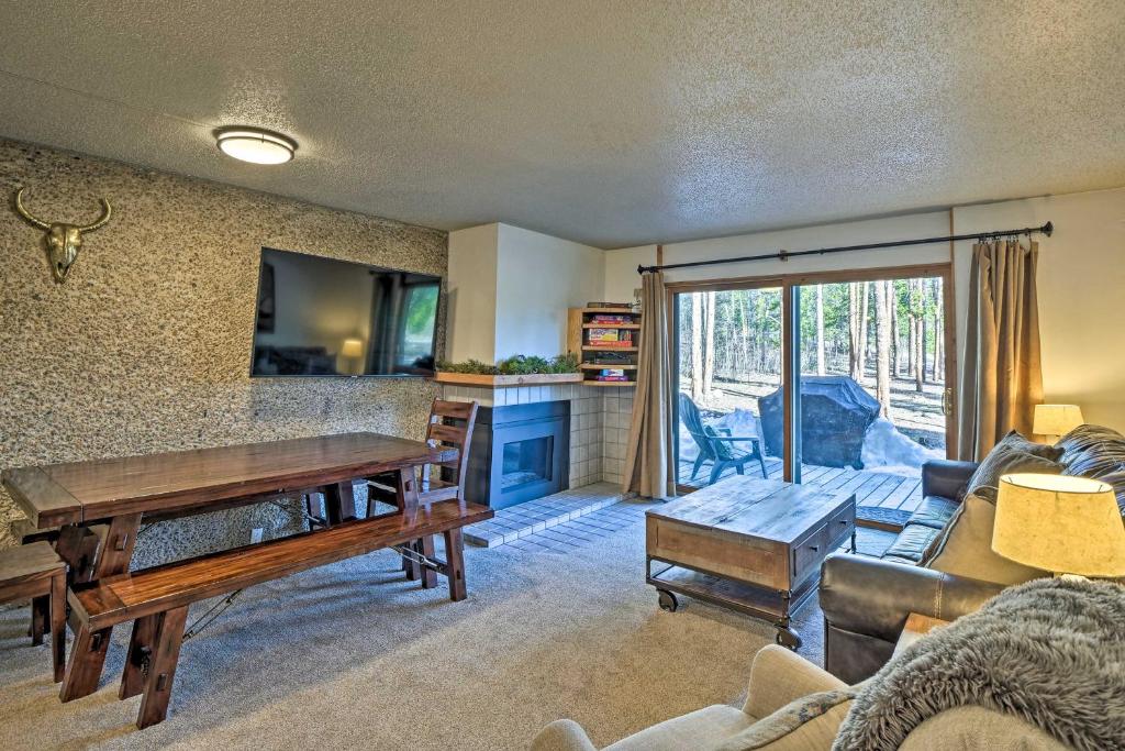 a living room with a table and a couch at Beautiful Breck Townhome with Pool 1 Mi to Main St! in Breckenridge