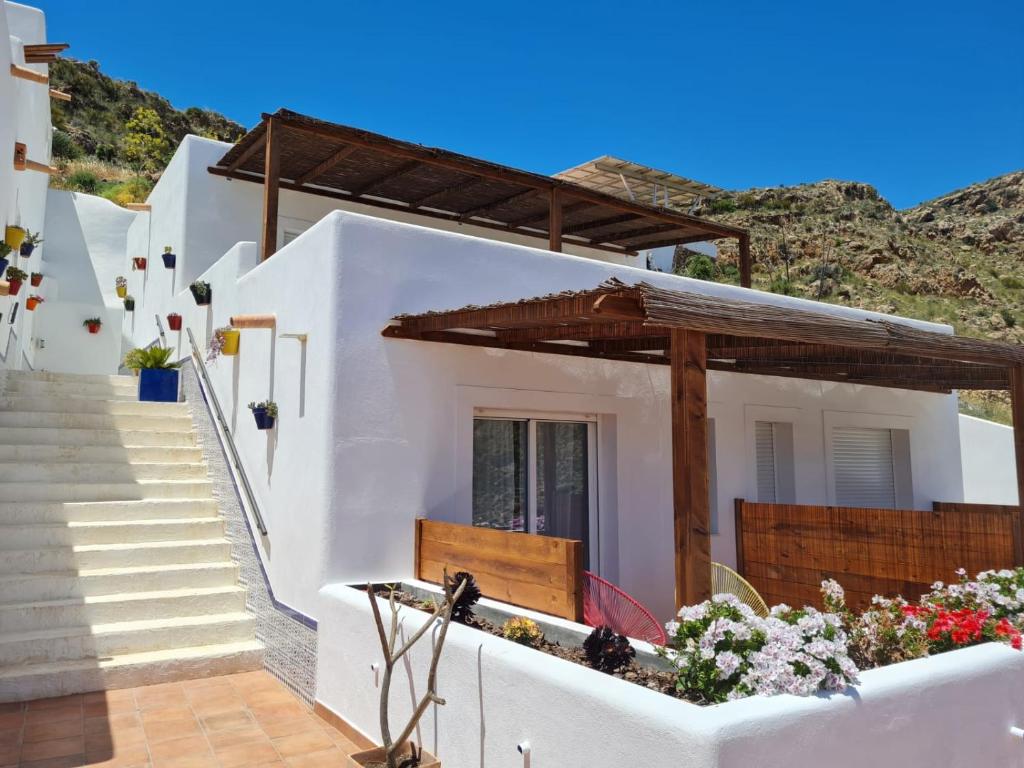 uma casa branca com escadas e flores em frente em Casa Sol y Luz - casa rural em Carboneras