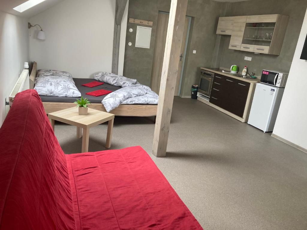 salon z 2 łóżkami i czerwoną kanapą w obiekcie Apartmány V ráji w mieście Žďár