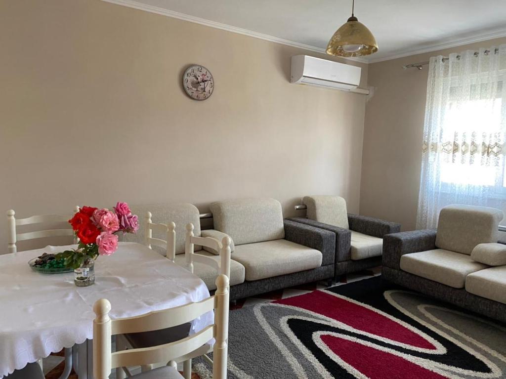 un soggiorno con tavolo e fiori di Dibra's Apartment a Shkodër