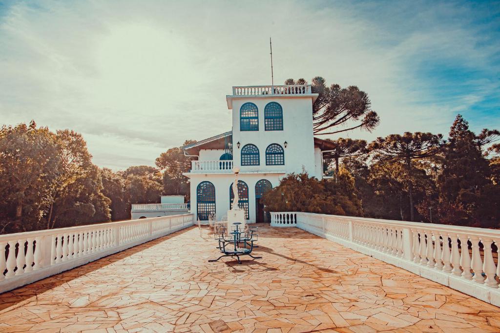 a white building with a table on a bridge at Hotel Gramado Palace in Gramado
