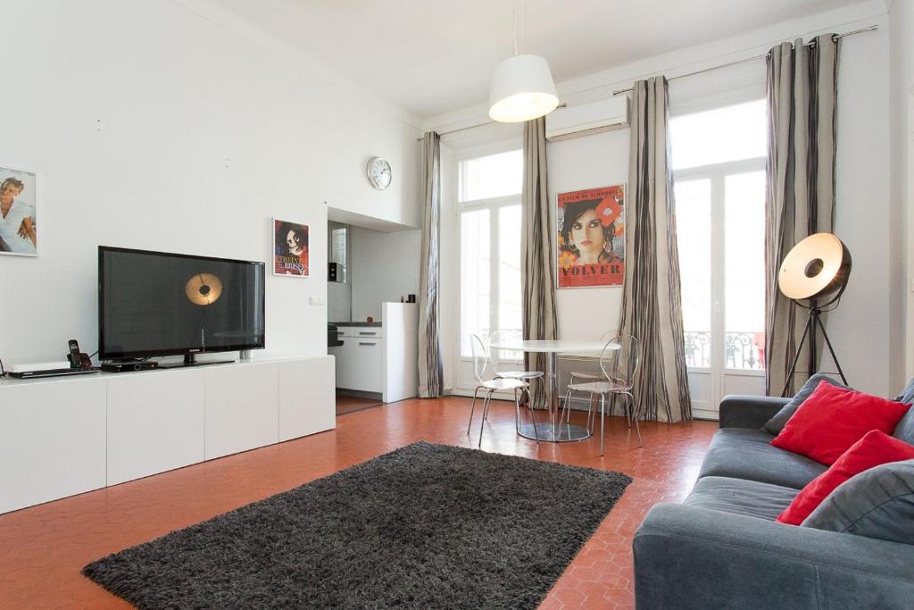 un salon avec un canapé bleu et une télévision dans l'établissement 1 bedroom appartement Cannes (Carnot), à Cannes