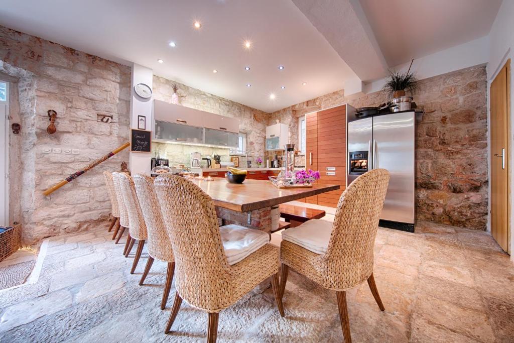 B&B Villa Vis في فيس: مطبخ مع طاولة وكراسي خشبية