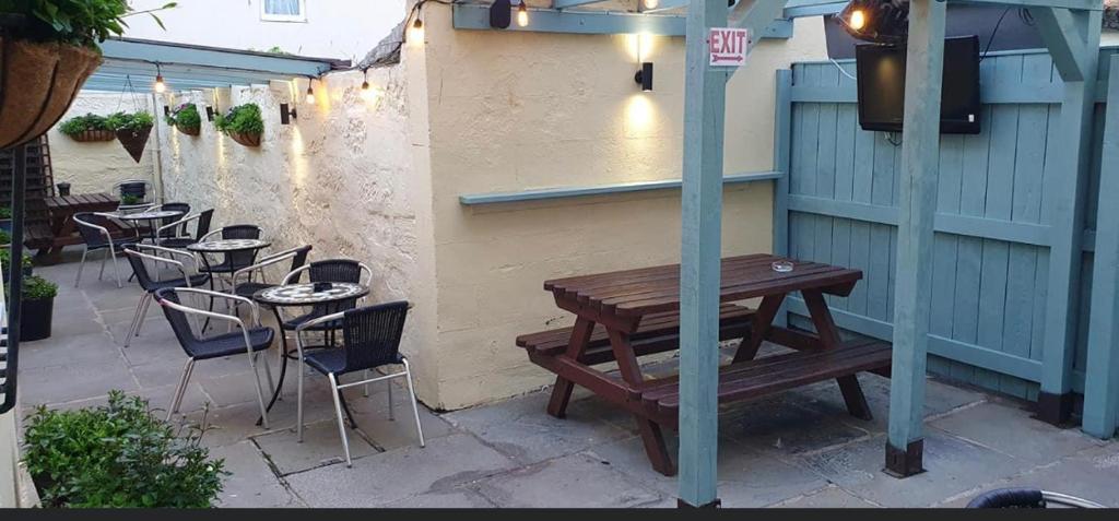 a wooden table and chairs on a patio at The Royal George Staithes in Staithes