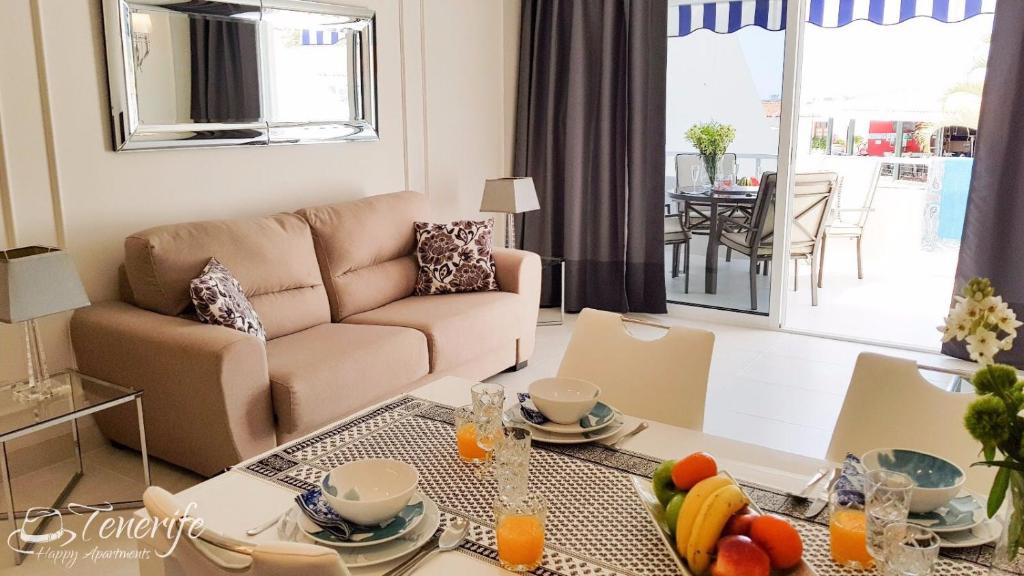 a living room with a couch and a table with fruit on it at Apartament Malibu Blue in Adeje